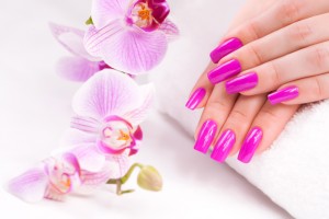 female manicure with pink orchid and towel